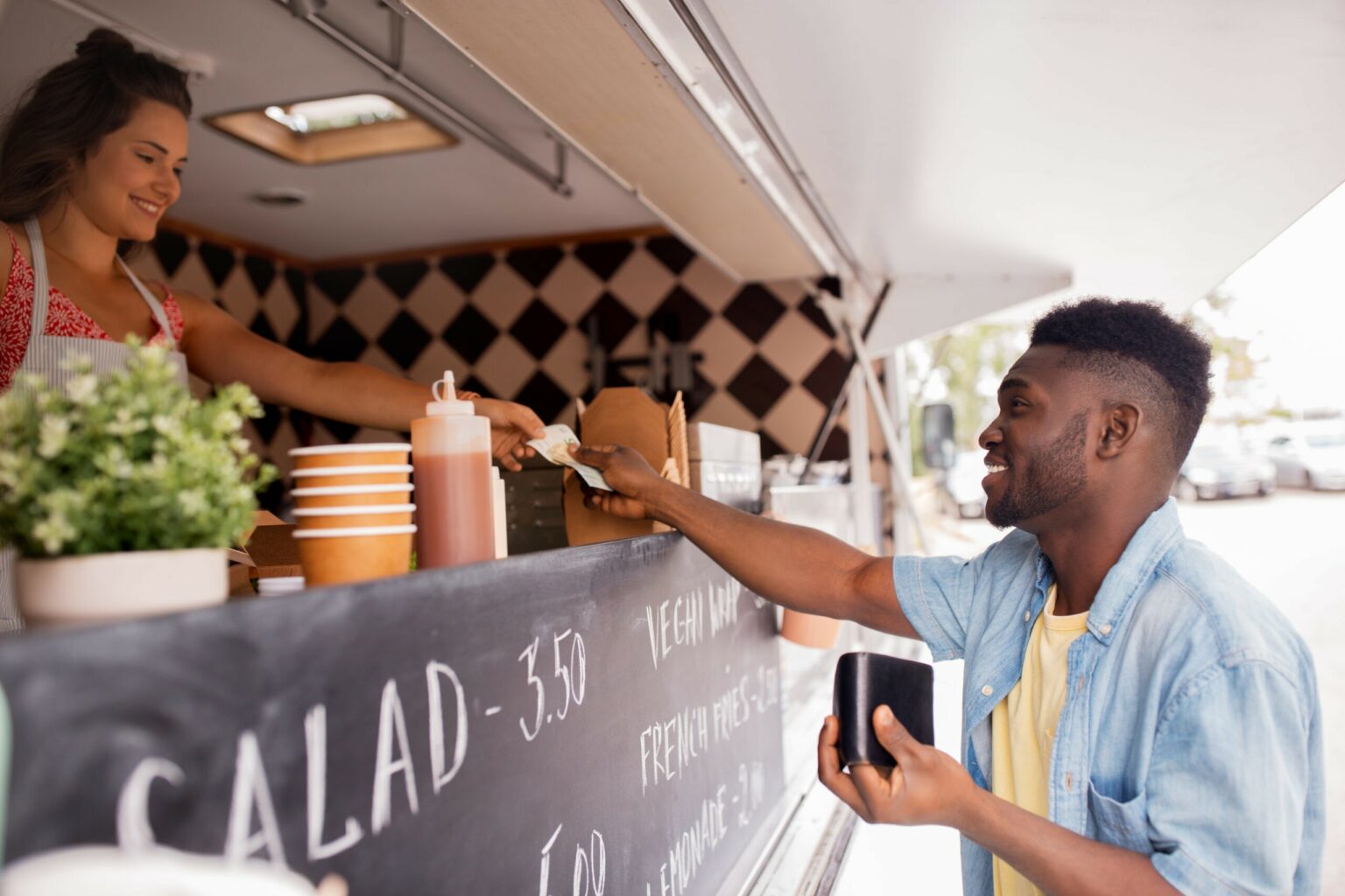 man paying woman in food truck